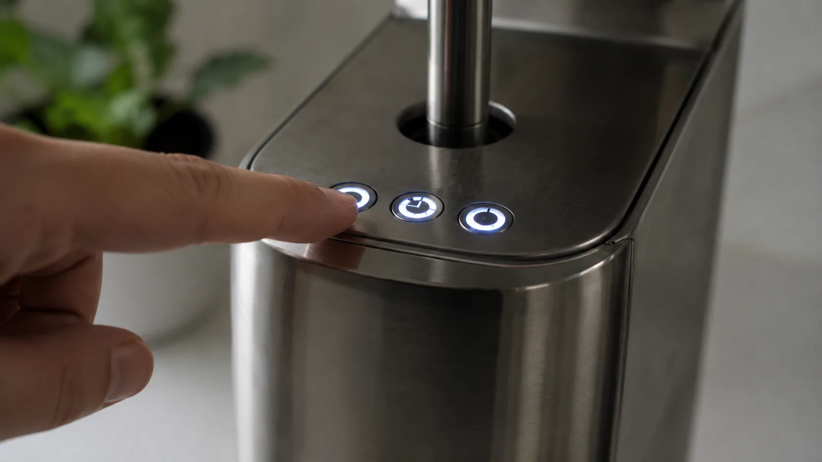 The three backlit buttons of a De'Longhi Dedica flashing