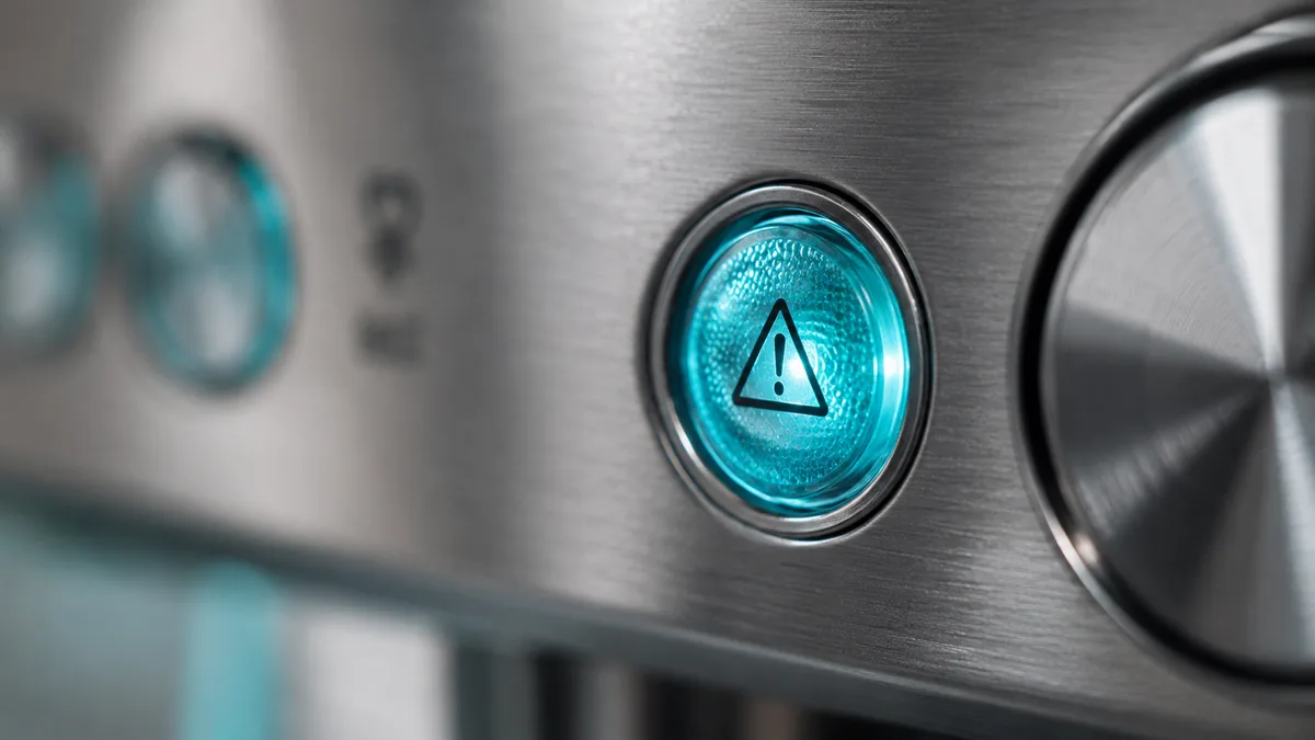 A warning light glowing on an espresso machine control panel